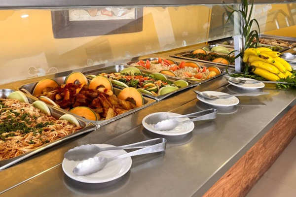 Área de restaurante con servicio de buffet y mesas con vista al exterior